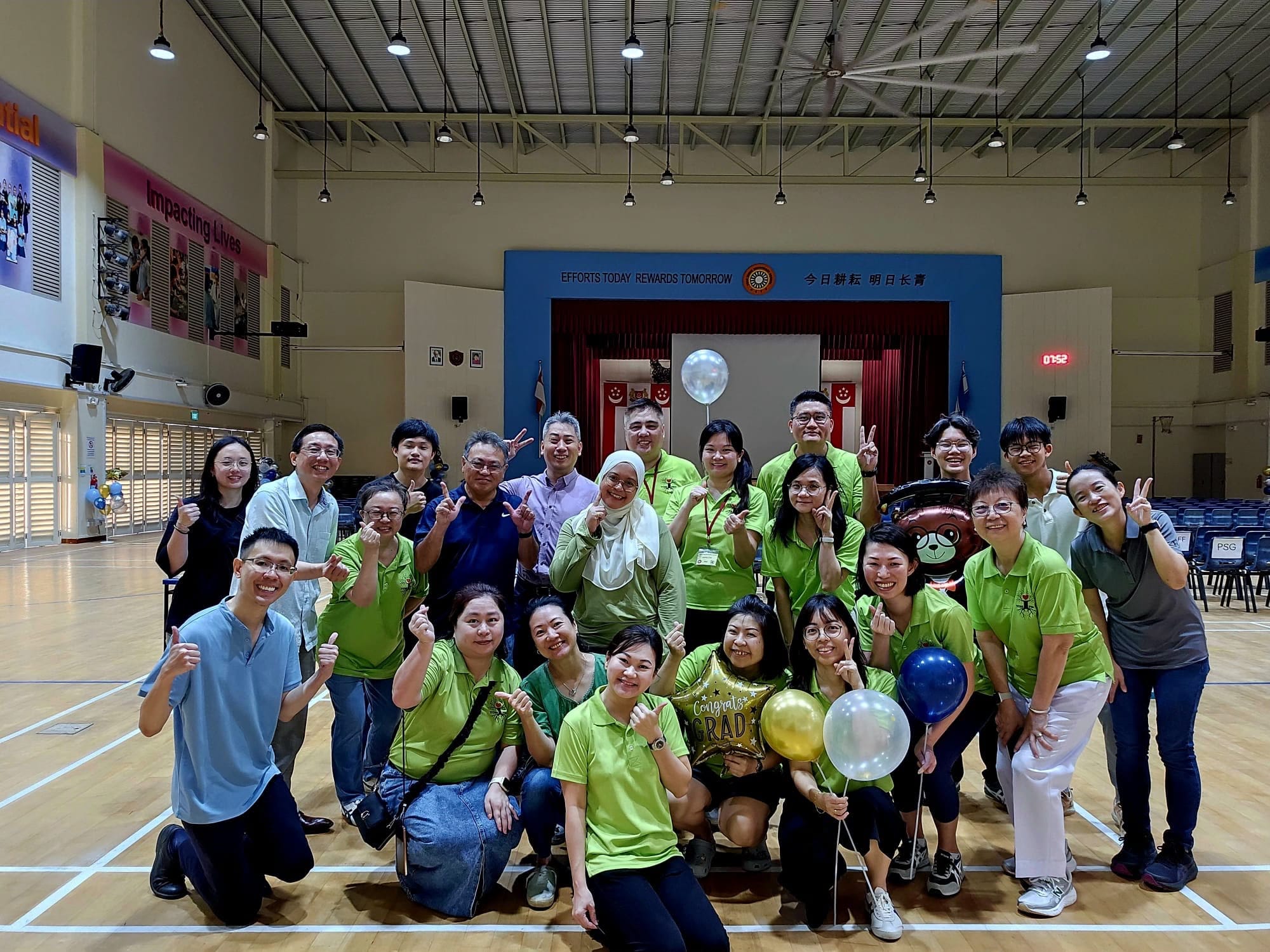 A group of people posing at the hall with balloons as props